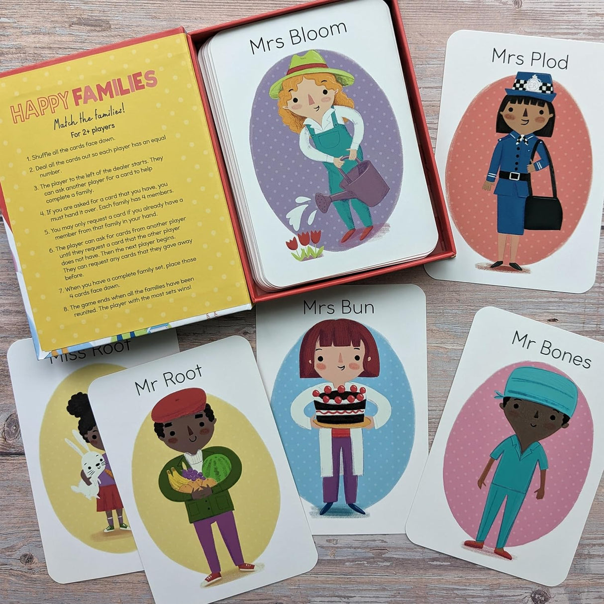 Card game with illustrated characters and instructions on a wooden surface